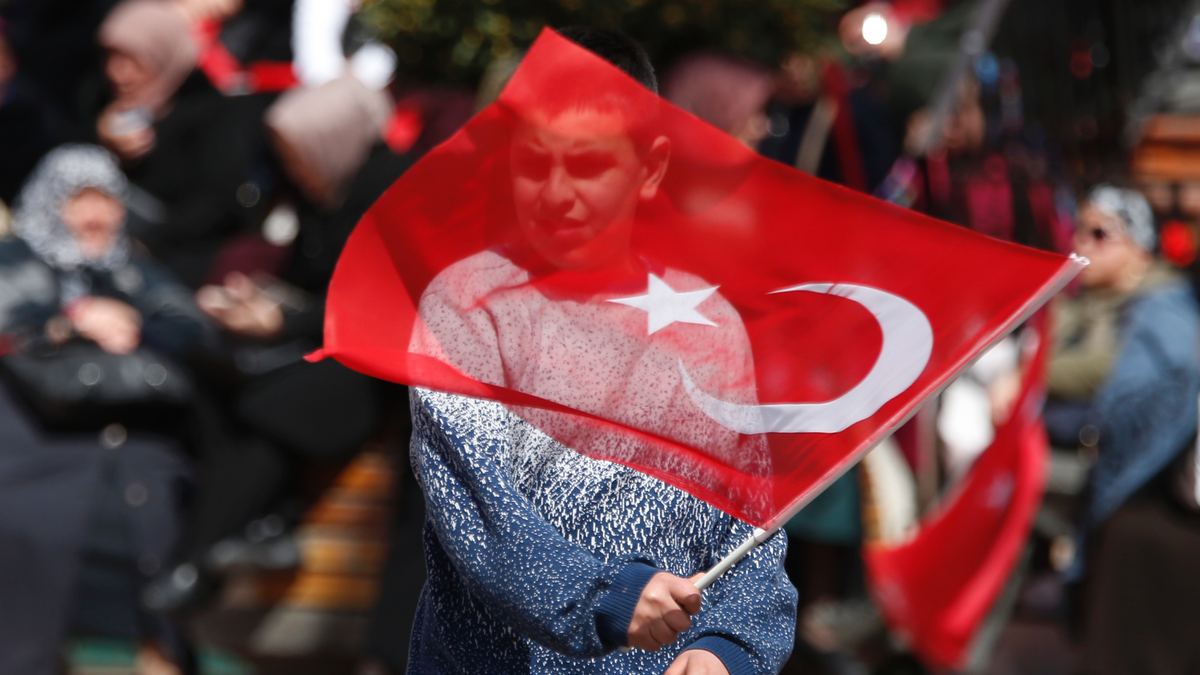 A supporter of Turkey's President Recep Tayyip Erdogan waves a flag at a rally of his ruling Justice and Development Party's (AKP), in Istanbul, Friday, March 29, 2019, ahead of local elections scheduled for March 31, 2019. (AP Photo/Lefteris Pitarakis)