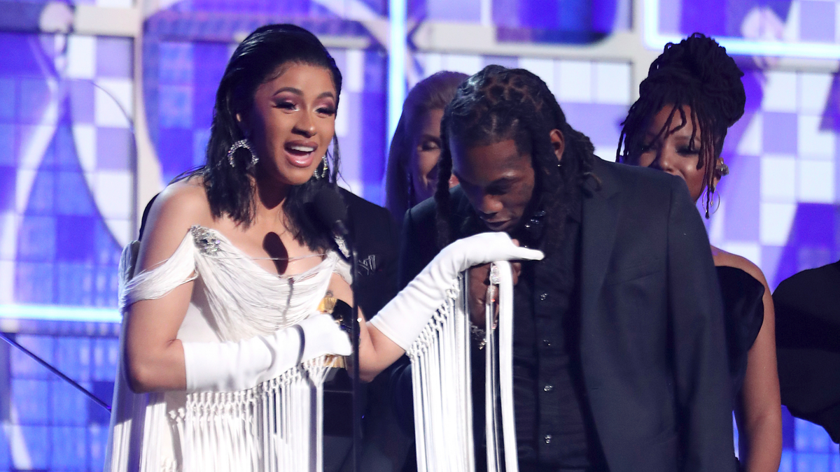 Cardi B, left, accepts the award for best rap album for "Invasion of Privacy" as husband Offset kisses her hand at the 61st annual Grammy Awards on February 10, 2019 in Los Angeles, Calif.