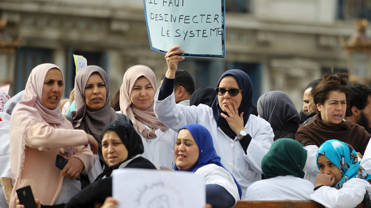An Algerian woman holds a placard that reads, 'we need to disinfect the system' during a protest in Algiers, Algeria, Tuesday, March 19, 2019. (AP Photo/Anis Belghoul)
