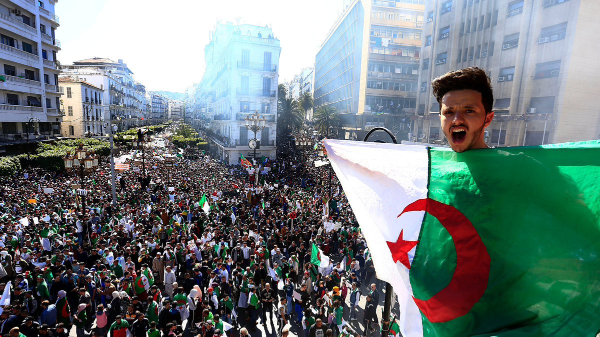 Algerian shouts as he holds the national flag during a protest in Algiers, Algeria, Friday, March 15. Tens of thousands of people gathered Friday in Algeria's capital and other cities amid heavy security for what could be decisive protests against longtime leader Abdelaziz Bouteflika. (AP Photo/Toufik Doudou)