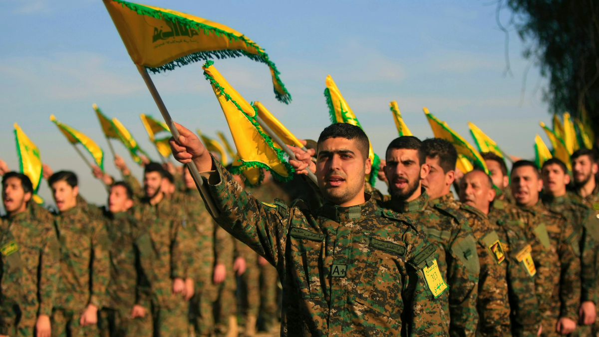 Hezbollah fighters hold flags