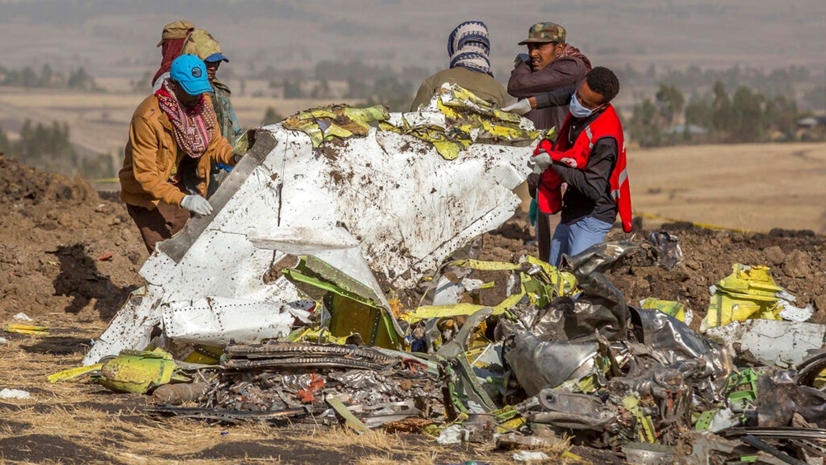 Rescuers work at the scene of an Ethiopian Airlines flight crash near Bishoftu, or Debre Zeit, south of Addis Ababa, Ethiopia, Monday, March 11, 2019. A spokesman says Ethiopian Airlines has grounded all its Boeing 737 Max 8 aircraft as a safety precaution, following the crash of one of its planes in which 157 people were killed. (AP Photo/Mulugeta Ayene)