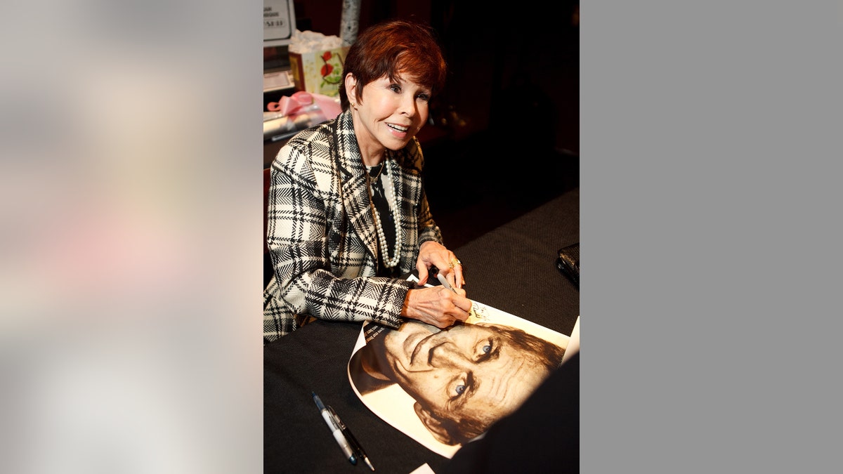Neile Adams signs a poster of Steve McQueen, her former husband, during a book signing of her autobiography "My Husband, My Friend," on March 31, 2012 at American Cinematheque's Egyptian Theatre in Hollywood, California.