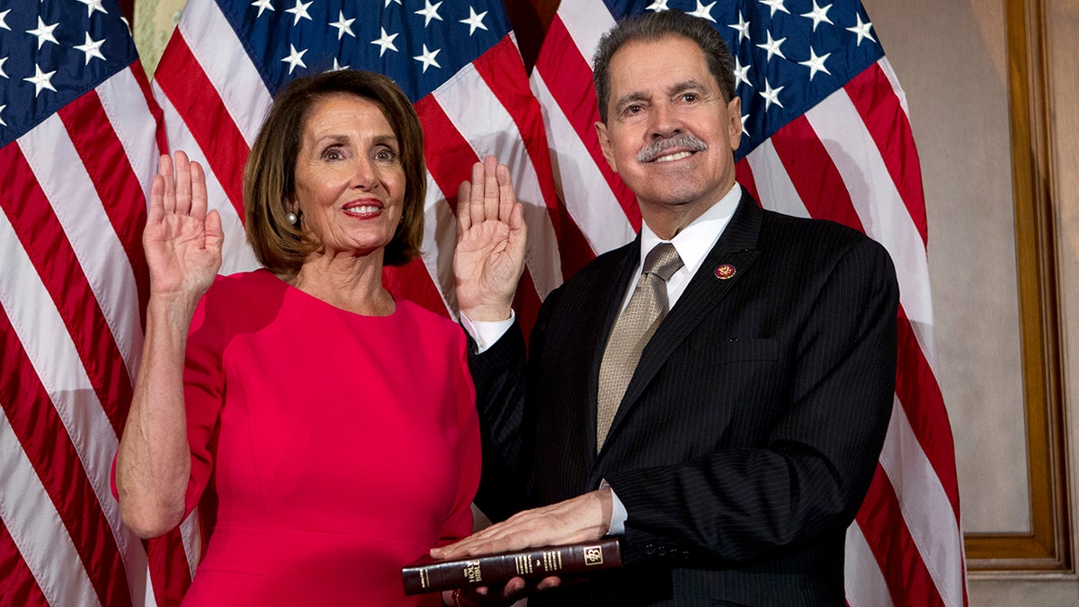 FILE - In this Jan. 3, 2019, file photo, House Speaker Nancy Pelosi of Calif., administers the House oath of office to Rep. Jose Serrano, D-N.Y., during a ceremonial swearing-in on Capitol Hill in Washington, during the opening session of the 116th Congress. Serrano, a 16-term Democrat from the South Bronx, says he has Parkinson’s Disease and will retire at the end of his term. (AP Photo/Jose Luis Magana, File)