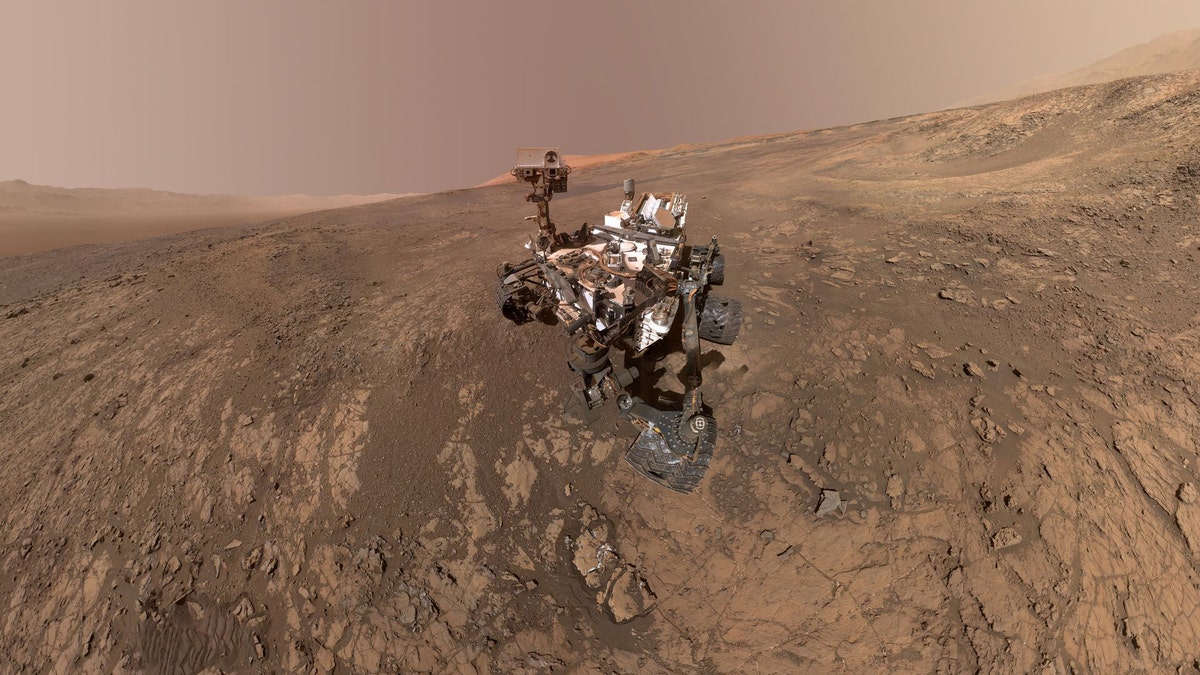 This self-portrait of NASA's Curiosity Mars rover shows the vehicle on Vera Rubin Ridge in Gale crater on Mars. North is on the left and west is on the right, with Gale crater's rim on the horizon of both edges. This mosaic was assembled from dozens of images taken by Curiosity's Mars Hands Lens Imager (MAHLI). They were all taken on Jan. 23, 2018, during Sol 1943. (Credit: NASA/JPL-Caltech/MSSS)