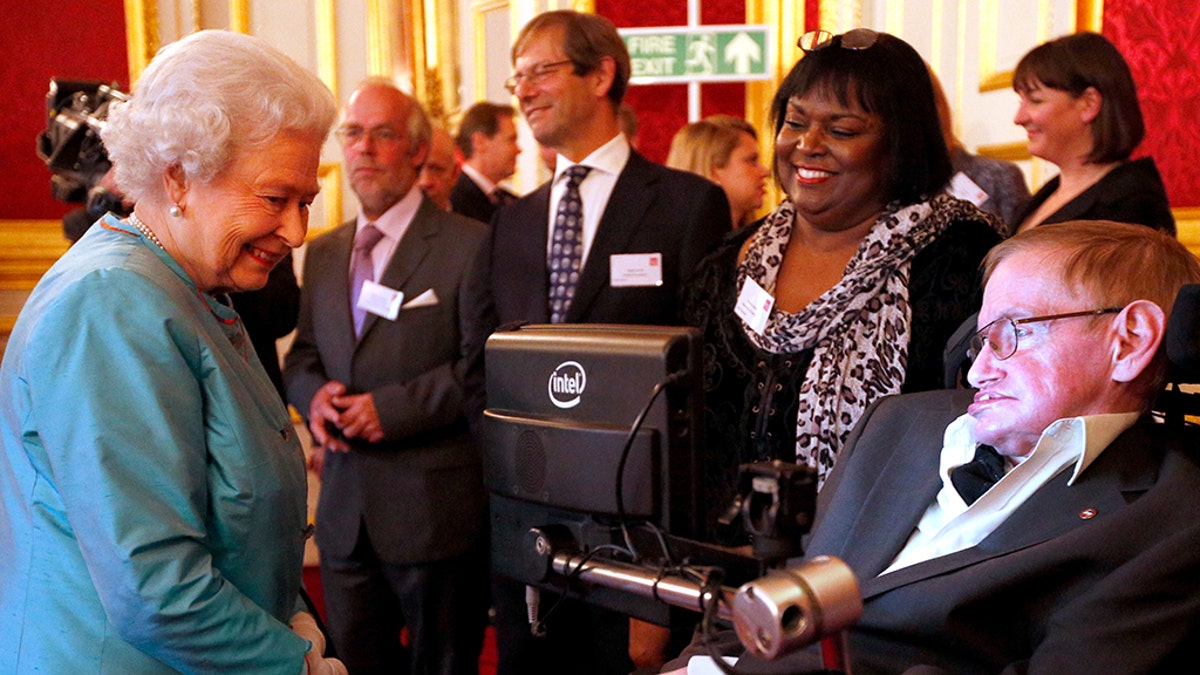 Queen Elizabeth II meets Professor Stephen Hawking (R) during a reception for Leonard Cheshire Disability in the State Rooms, St James's Palace on May 29, 2014 in London. Hawking is accompanied by Patricia Dowdy.