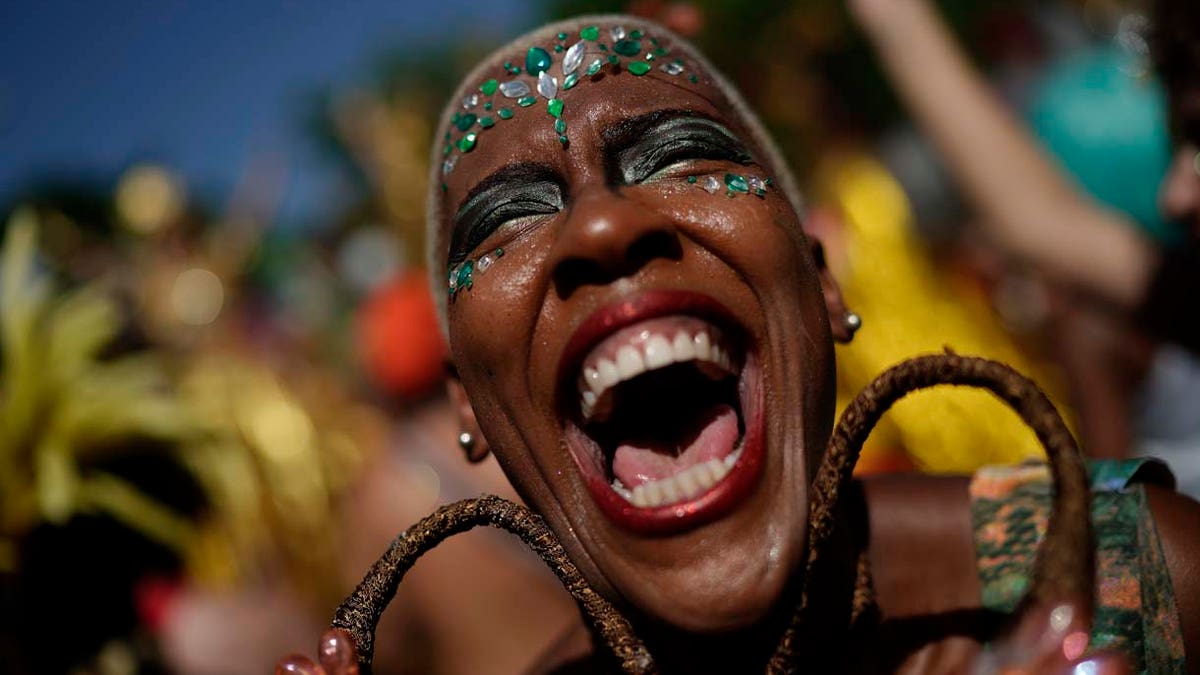 A reveler in costume laughs during the "Cordao do Boitata" street party in Rio de Janeiro, Brazil, Sunday, Feb. 24, 2019, one of the many parades before the official start of Carnival on March 1. (AP Photo/Leo Correa)