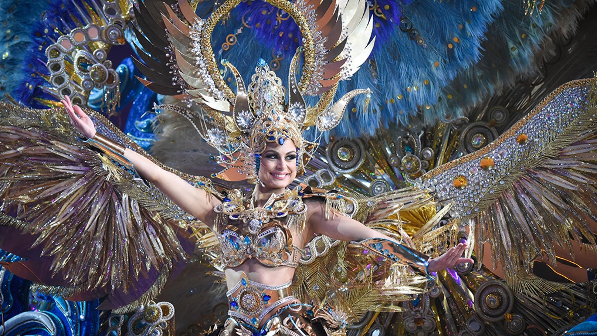 TOPSHOT - A nominee for queen performs during the main stage of the Carnival of Santa Cruz in Santa Cruz de Tenerife on the Spanish Canary island of Tenerife, on February 07, 2018. The costumes are more than five meters high and over 80 kilos in weight. The event began on January 12 and finishes on February 18 with orchestras playing Caribbean and Brazilian rhythms throughout the festivities that range from elections for the Carnival Queen, the Junior Queen and the Senior Queen, to children and adult murgas (satirical street bands), comparsas (dance groups) and street performances. / AFP PHOTO / DESIREE MARTIN (Photo credit should read DESIREE MARTIN/AFP/Getty Images)