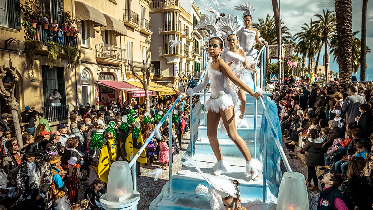 Revelers in their colorful costumes dance on their float during the children carnival parade in Sitges. (Photo by Matthias Oesterle/Corbis via Getty Images)