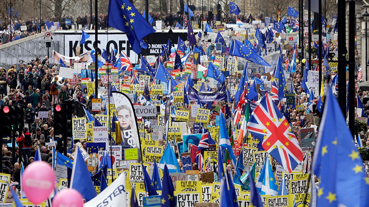 Demonstrators carry posters and flags during a Peoples Vote anti-Brexit march in London, Saturday.
