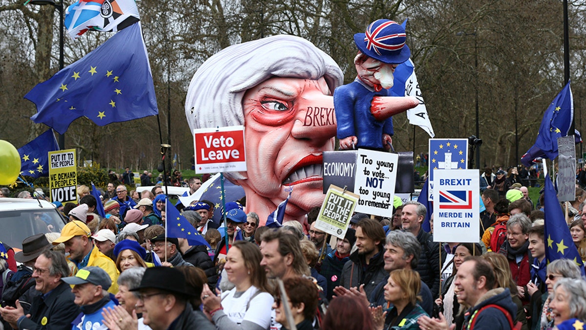 A puppet character depicting British Prime Minister Theresa May is brandished among Anti-Brexit campaigners, during the People's Vote March in London, Saturday March 23, 2019. Protesters are gathering in central London before what is widely predicted to be a massive march in favour of a second Brexit referendum. (Yui Mok/PA via AP)