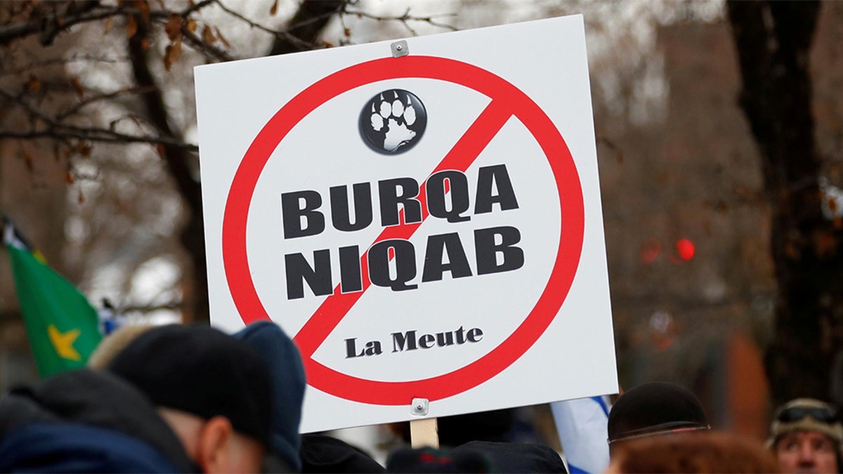 A sign opposing religious attire is displayed during protests by groups La Meute and Storm Alliance in Quebec City, Quebec, Canada November 25, 2017. REUTERS/Mathieu Belanger