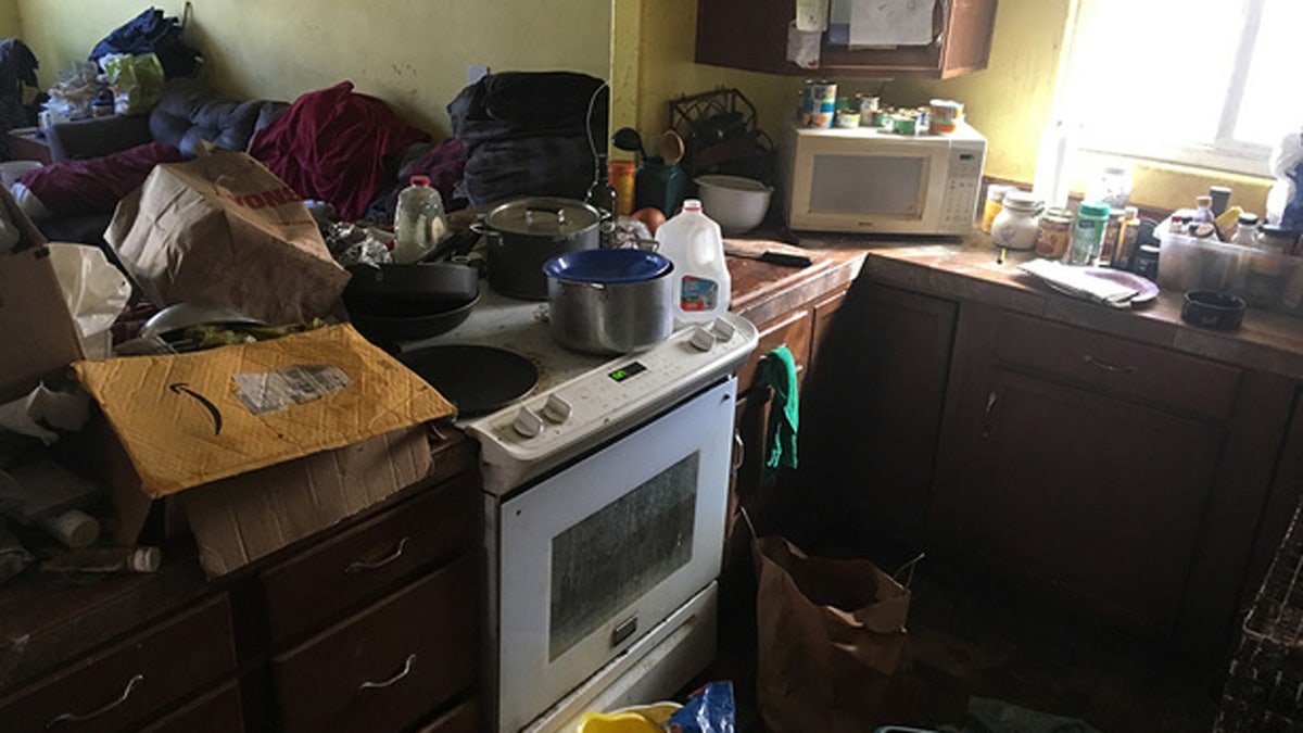 "Excessive animal fecal and urine matter" throughout the entire home, in addition to floors and countertops piled with trash.