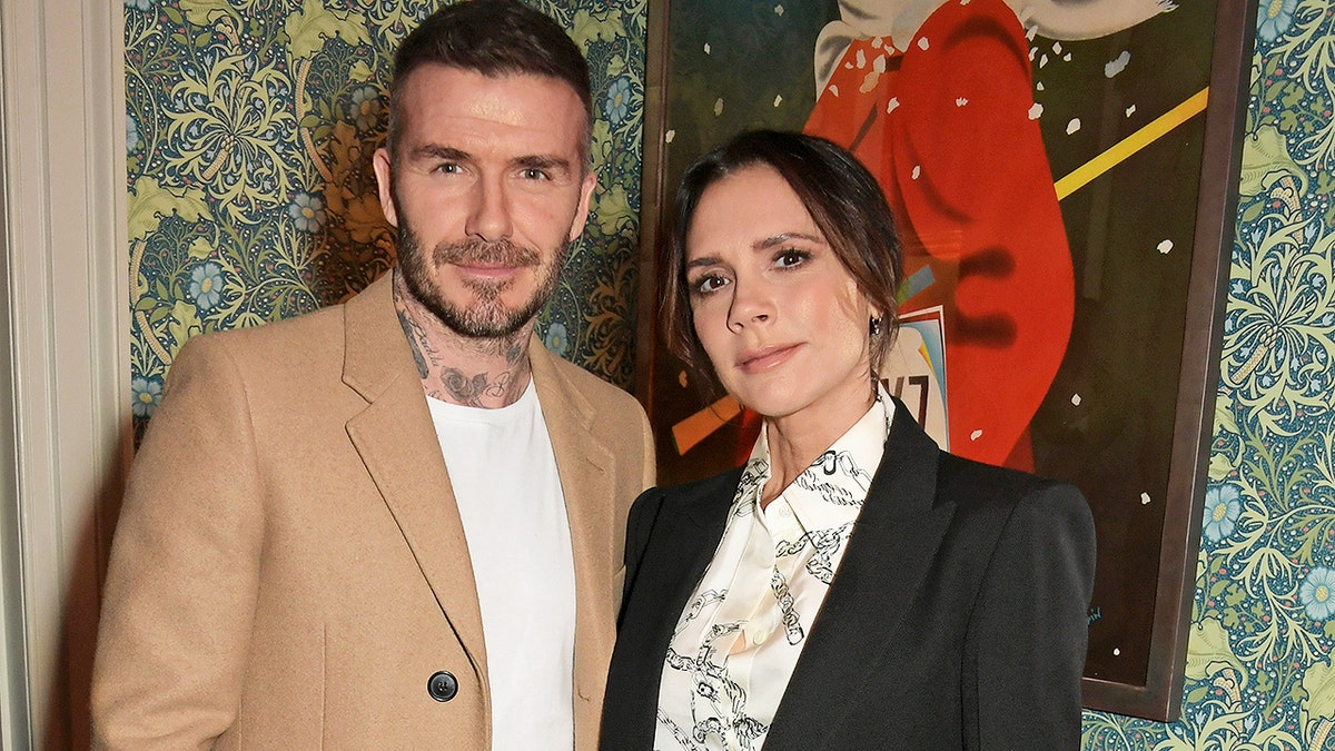 Victoria and David Beckham pose for a photo