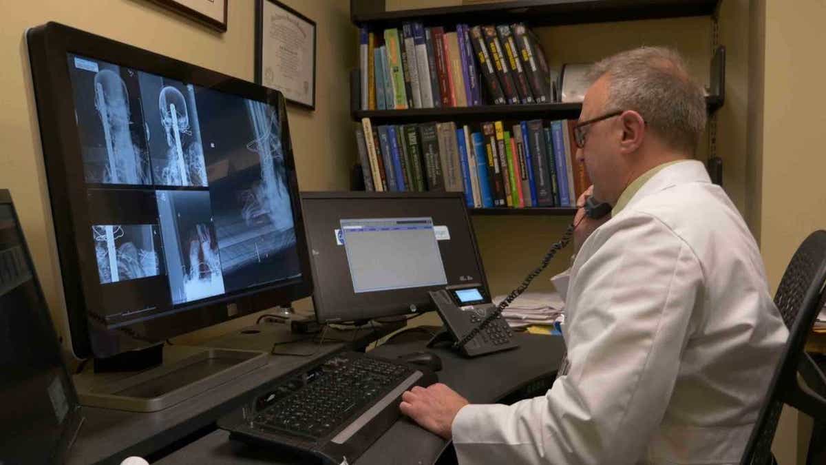 Dr. Sauerwine Scott examines X-rays of the Peruvian mummy.