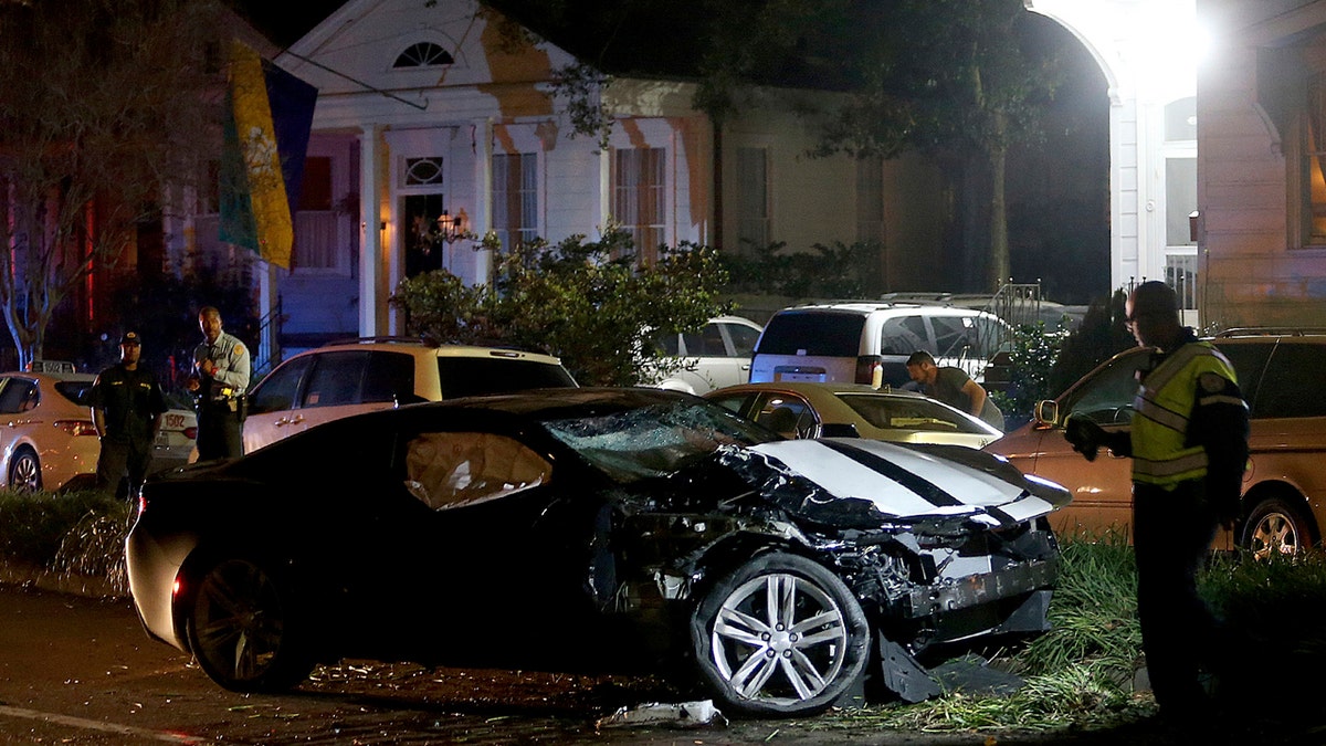 New Orleans Police examine a Chevy Camaro on Esplanade Avenue in New Orleans that struck multiple people, killing several and injuring others, after the Endymion Mardi Gras parade finished passing nearby on Saturday, March 2, 2019.