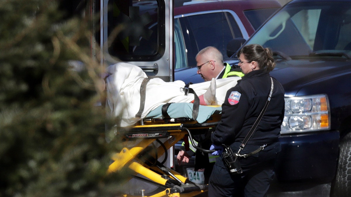 Emergency medical technicians carry a person on a stretcher into an ambulance outside the Quality Inn on Thursday, March 28, 2019, in Manchester, N.H.
