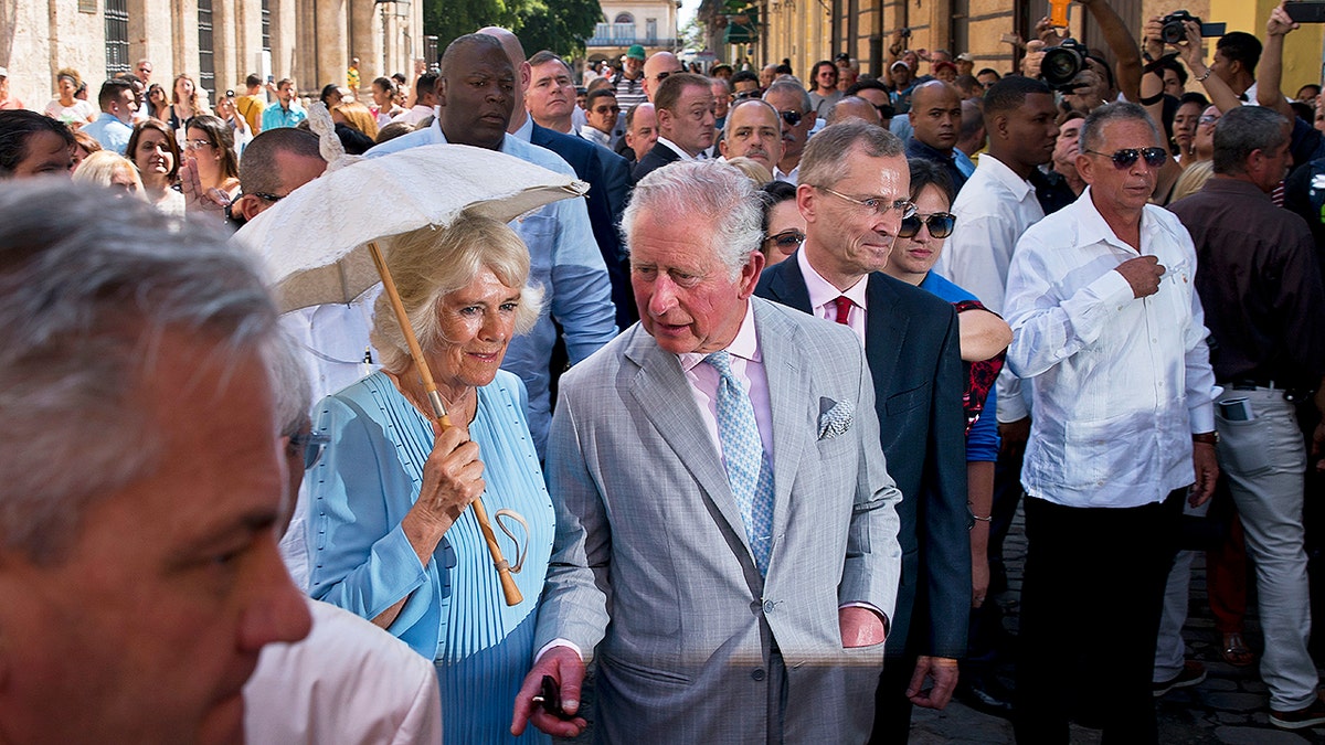 Britain's Prince Charles, the Prince of Wales, center, and his wife Camilla, Duchess of Cornwall, take a guided tour of the historical area of Havana, Cuba, Monday, March 25, 2019. The royal couple began the first official trip to Cuba by the British royal family on Sunday, in a pomp-filled display of disagreement with the Trump administration's strategy of economically isolating the communist island. (AP Photo/Ramon Espinosa)