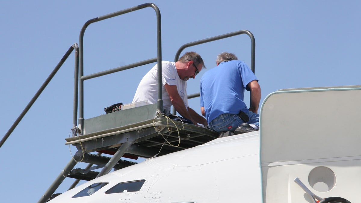 From left, Northrop Grumman technicians Joe McKee and Al Fournier work to repair aerial refueling equipment atop the T-3 test bed version of the E-8C Joint STARS aircraft during Bold Quest at Nellis Air Force Base, Nev., last month. (U.S. Air Force photo)