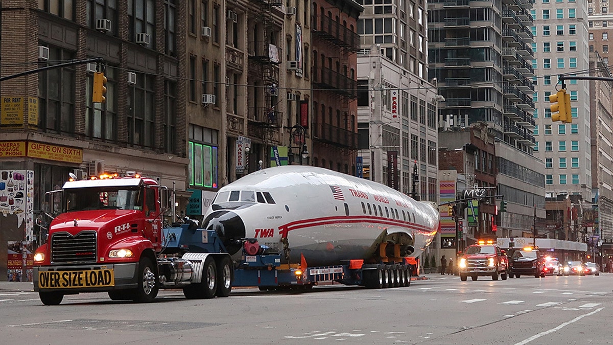 NEW YORK, NY - MARCH 23: The fuselage of a Trans World Airlines airplane is transported up 6th Avenue on March 23, 2019, in New York City. The jet was taken to Times Square and will end up at the new TWA Hotel at JFK airport.