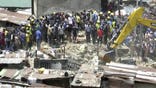 In this image taken from video rescue workers and emergency teams work at the scene of a building collapse in Lagos, Nigeria, Wednesday March 13, 2019. There was no immediate official word on numbers of casualties.