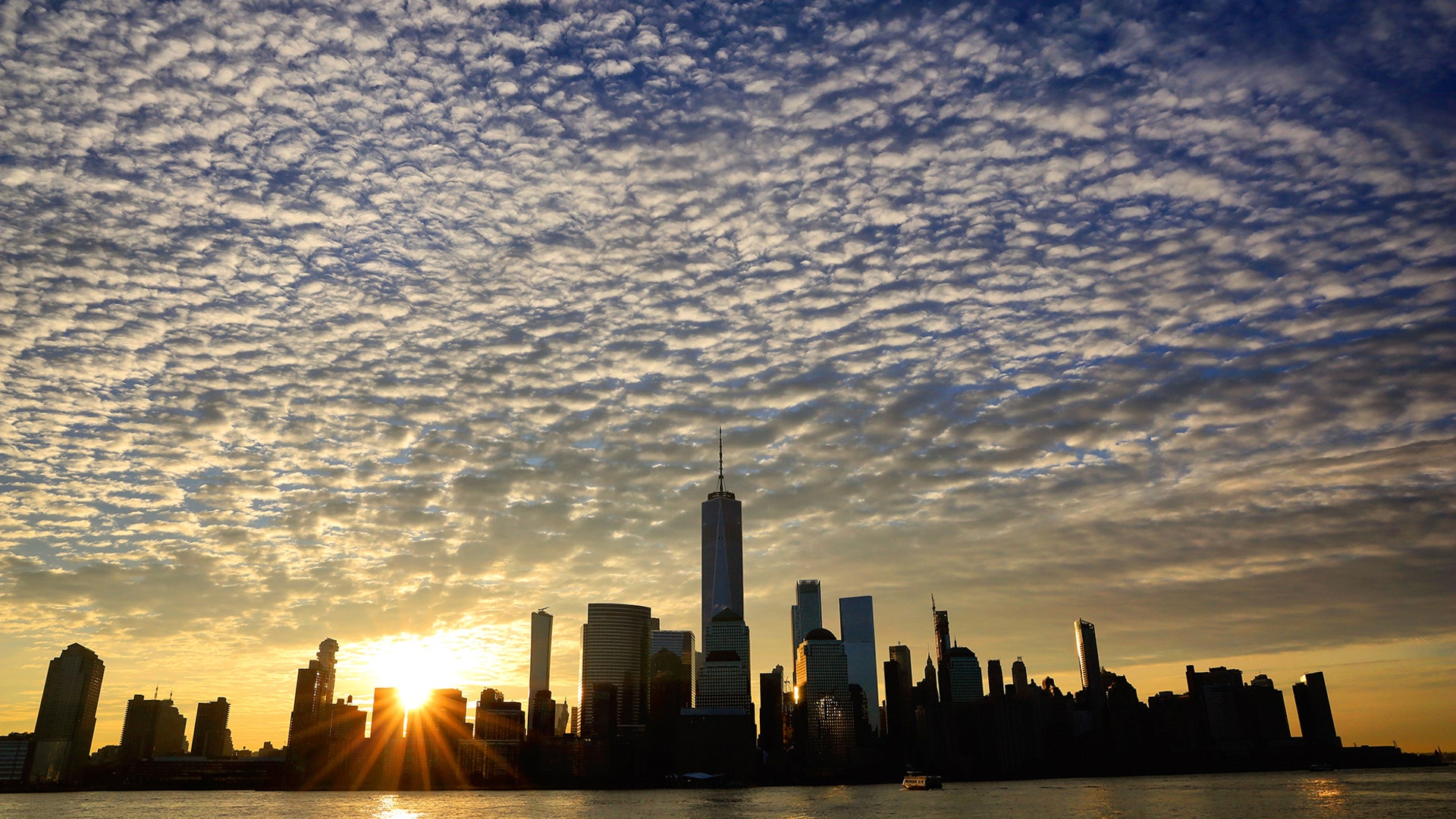 The sun rises behind the skyline of lower Manhattan in New York City, March 11, 2019.