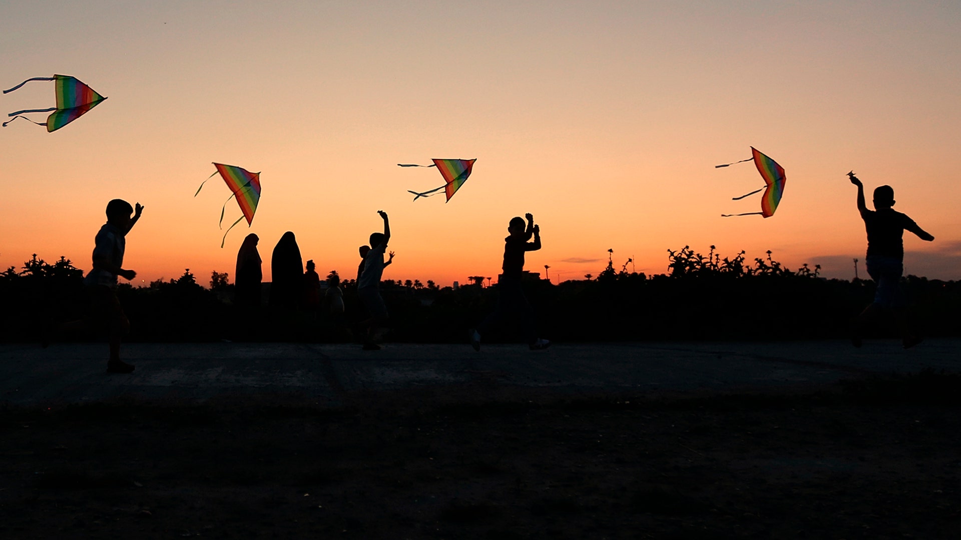 Children launch kites during Nowruz celebrations as the sun sets in Baghdad, Iraq, March 21, 2019. 