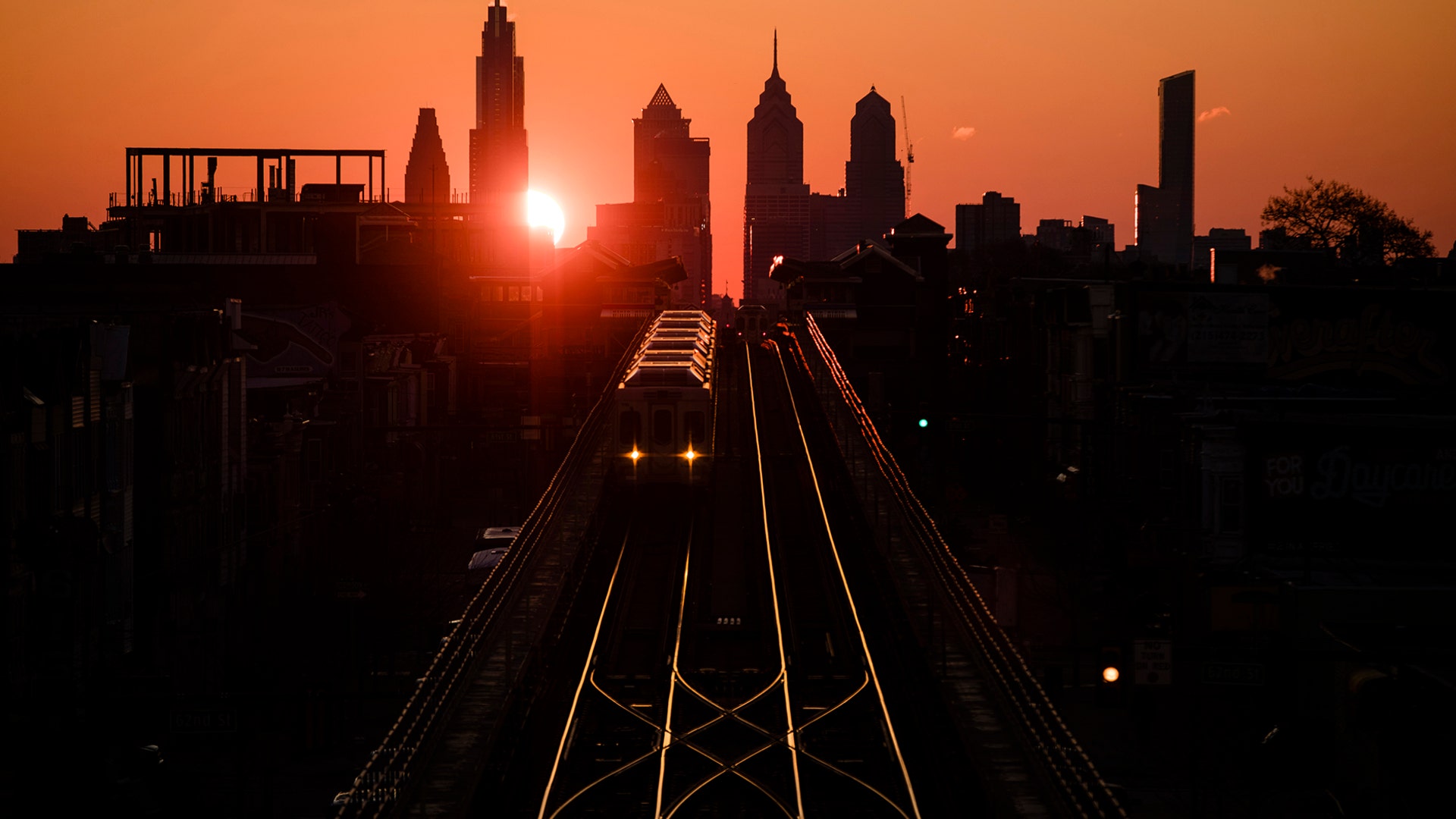 A train heads west as the sun rises from behind the city skyline in Philadelphia, March 6, 2019. 
