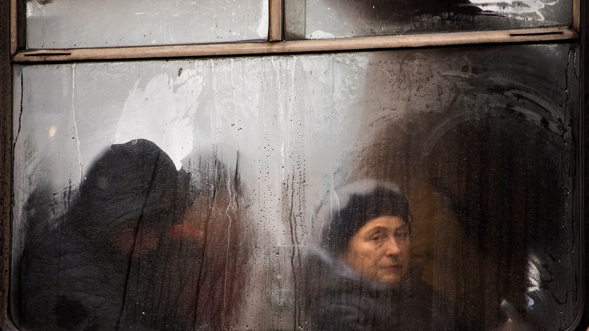 Commuters are seen through the window of a public bus as they travel in central Vinnytsia, Ukraine, March 27, 2019. 