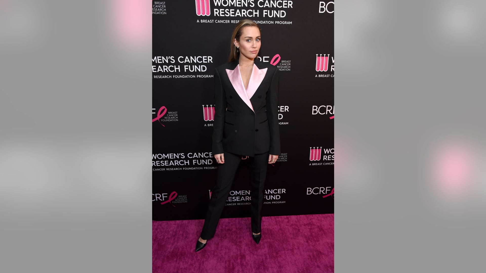Miley Cyrus looks chic in a black and pink pantsuit while posing on the red carpet for the WCRF's "An Unforgettable Evening" event at the Beverly Wilshire Four Seasons Hotel on February 28, 2019 in Beverly Hills, Calif.