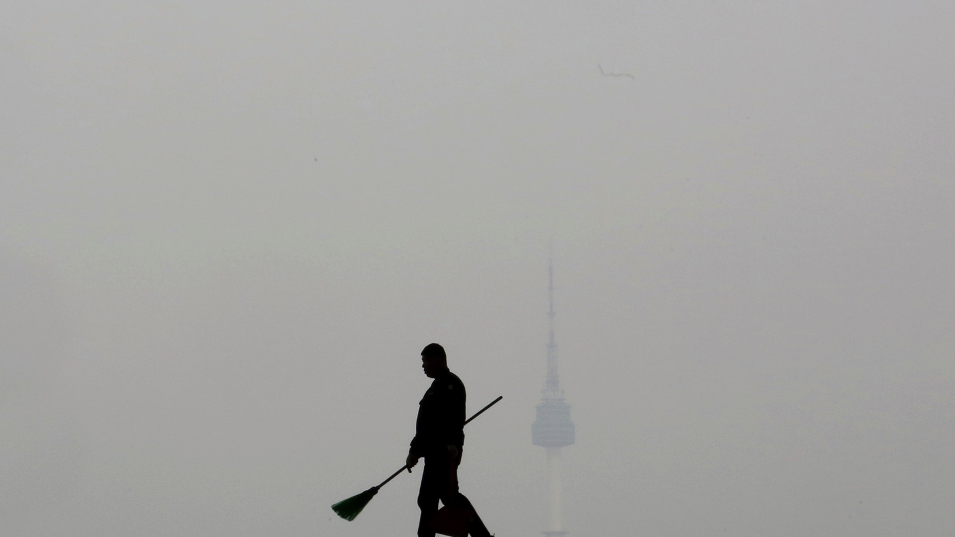 A worker is silhouetted as the cityscape is covered with a thick haze of fine dust particles, at the National Museum of Korea in Seoul, South Korea, March 12, 2019. 