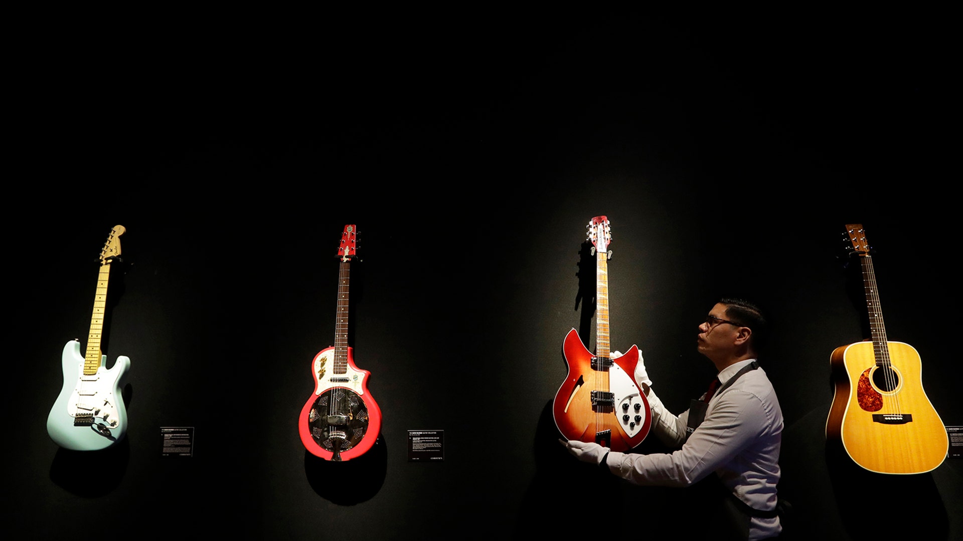 A technician arranges guitars from the collection of David Gilmour, guitarist, singer and songwriter of Pink Floyd, at Christie's auction rooms in London, March 27, 2019. 