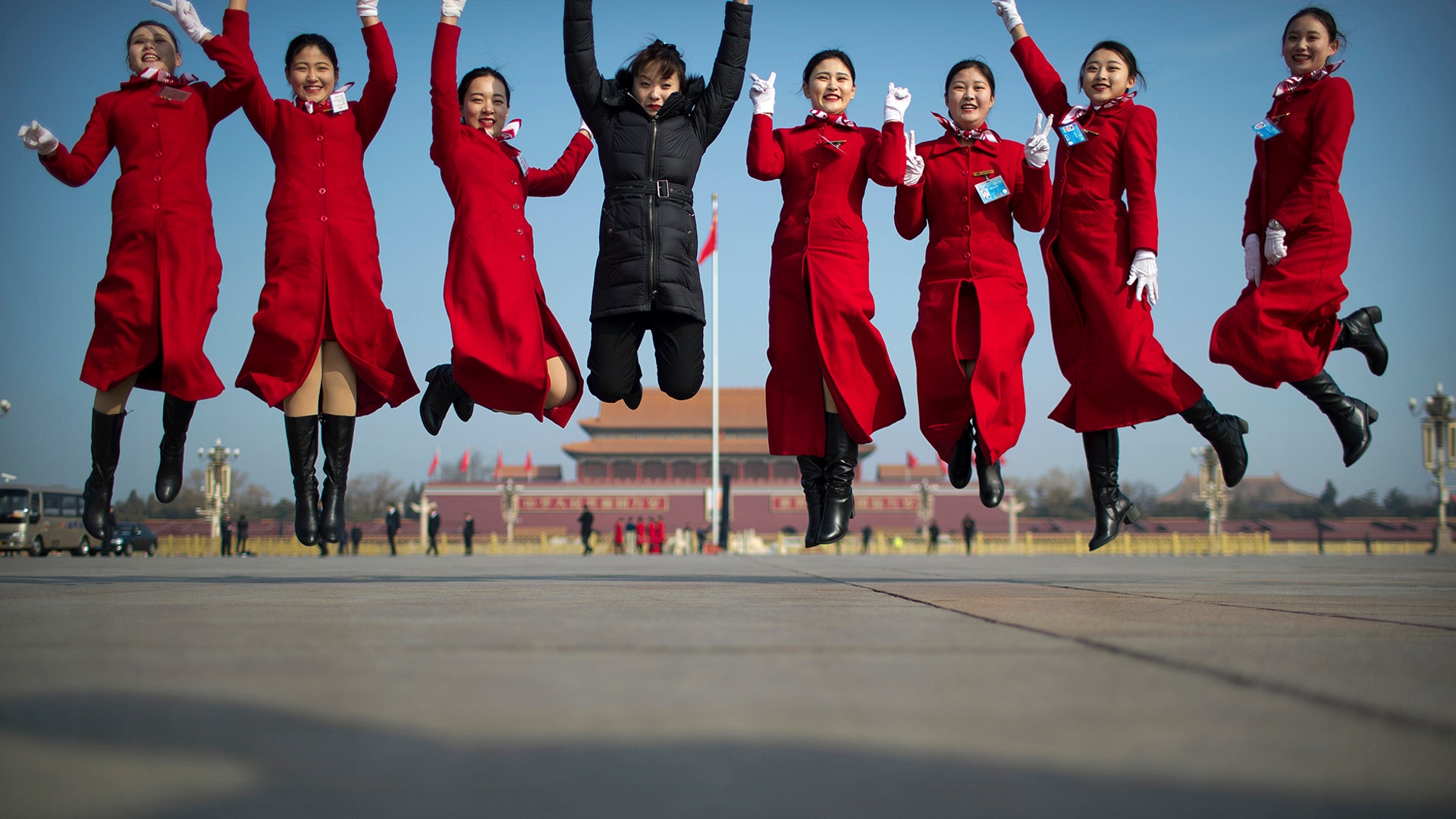 Ushers leap as they pose for a group photo during a meeting one day ahead of the opening session of China's National People's Congress at the Great Hall of the People in Beijing, March 4, 2019.