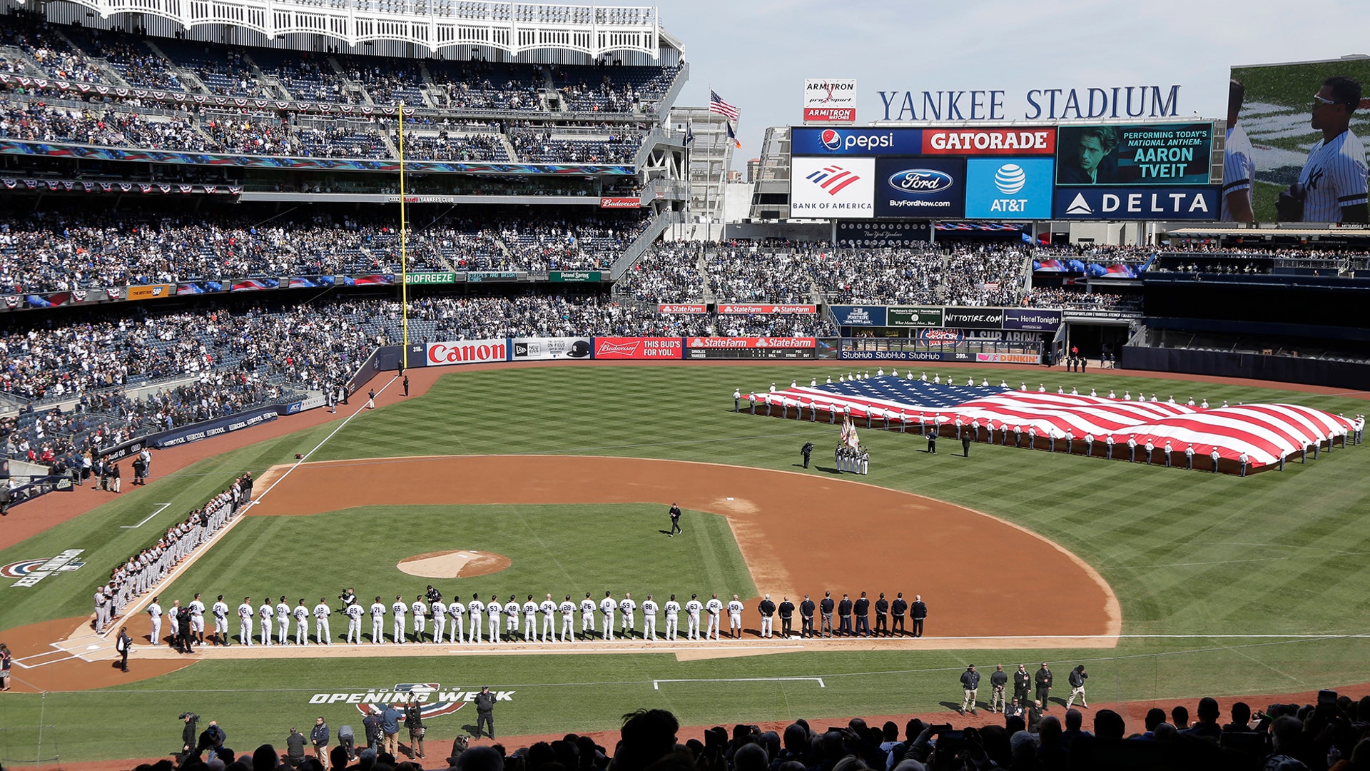 A large flag is unfurled during the national anthem before an opening day baseball game between the New York Yankees and the Baltimore Orioles at Yankee Stadium in New York, March 28, 2019.