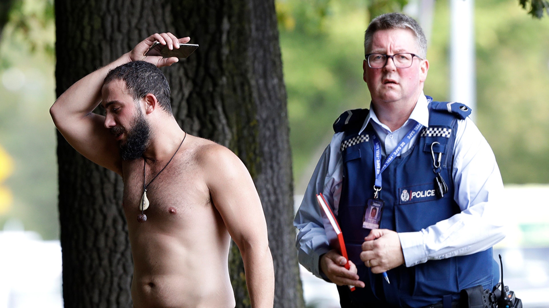 A police officer escorts a man away from a mosque in central Christchurch. (AP Photo/Mark Baker)