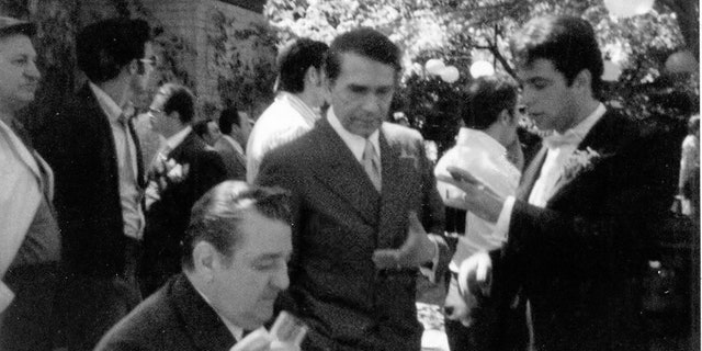 (L to R foreground) On the wedding set of "The Godfather," one of Joe Columbo's enforcers (seated), Richard Conte and Gianni Russo (standing.)