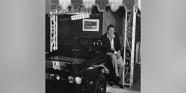 Gianni Russo, seated on the black Ferrari parked in front his State Street Club, poses for the album cover art, "Live from State Street."