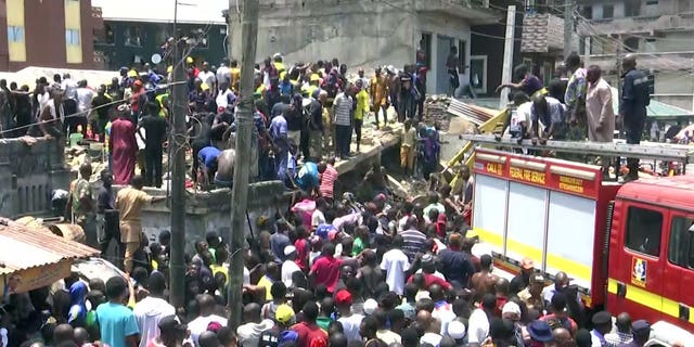 In this image taken from video rescue workers and emergency teams work at the scene of a building collapse in Lagos, Nigeria, Wednesday March 13, 2019. A three-story building has collapsed in Lagos, and rescuers rush to pull out scores of children thought to be inside. There was no immediate official word on numbers of casualties.