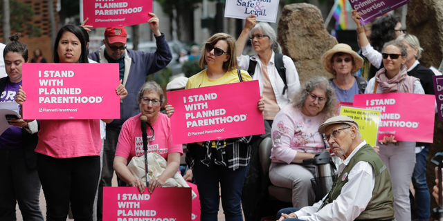 In this July 10, 2018, photo, protesters hold signs supporting Planned Parenthood in Seattle and against Brett Kavanaugh's nomination to the Supreme Court.