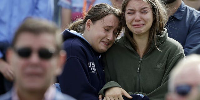 In this Friday, March 29, 2019, file photo, women react as the New Zealand national anthem is sung during a national remembrance service in Hagley Park for the victims of the March 15 mosque terrorist attack in Christchurch, New Zealand.