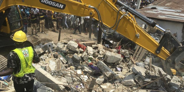 Emergency services attend the scene after a school building collapsed in Lagos, Nigeria, Wednesday March 13, 2019. Rescue efforts are underway in Nigeria after a three-storey school building collapsed while classes were in session, with some scores of children thought to be inside at the time.