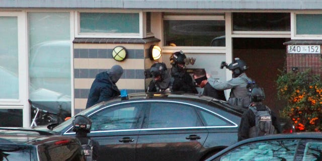 Gokmen Tanis, 37, is led away by police in Utrecht, Netherlands on Monday March 18, after a shooting incident on a tram.