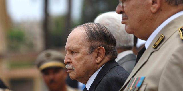 In this picture taken on June 27, 2012, Algerian President Abdelaziz Bouteflika, left, and his Army chief of staff, Gen. Ahmed Gaid Salah, review an honor guard before attending a military parade, in Cherchell near Algiers, Algeria. Algeria's powerful army chief, Ahmed Gaid Salah, insisted Wednesday that the military won't get mixed up in politics, a day after he said a constitutional process should be set in motion to declare ailing President Abdelaziz Bouteflika unfit for office. (AP Photo/Anis Belghoul)