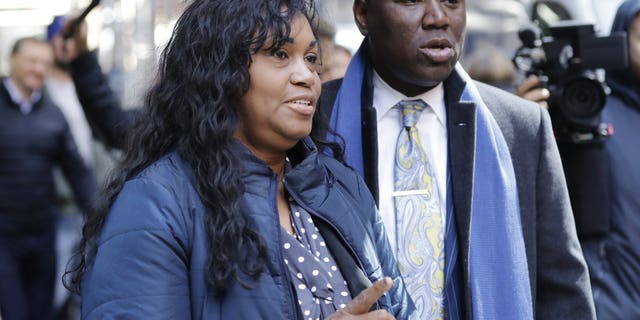 Tamara Lanier, left, and attorney Benjamin Crump, right arrive for a news conference near the Harvard Club Wednesday, March 20, 2019, in New York. Lanier, of Norwich, Conn., is suing the Harvard University for "wrongful seizure, possession and expropriation" of images she says depict two of her ancestors.
