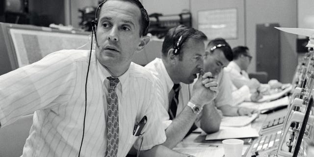 Spacecraft communicators are pictured as they keep in contact with the Apollo 11 astronauts during their lunar landing mission on July 20, 1969. From left to right are astronauts Charles M. Duke Jr., James A. Lovell Jr. and Fred W. Haise Jr. (NASA)