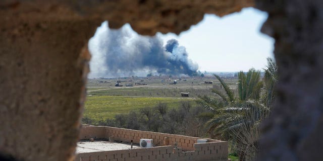Columns of black smoke billow from the last small piece of territory held by Islamic State militants as U.S. backed fighters pounded the area with artillery fire and occasional airstrikes in Baghouz, Syria, Sunday, March 3, 2019. (AP Photo/Andrea Rosa)