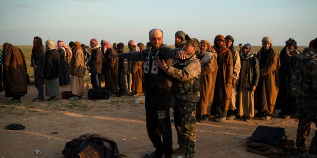 A man is frisked by a U.S.-backed Syrian Democratic Forces (SDF) fighter after being evacuated out of the last territory held by Islamic State militants, near Baghouz, eastern Syria.Â 