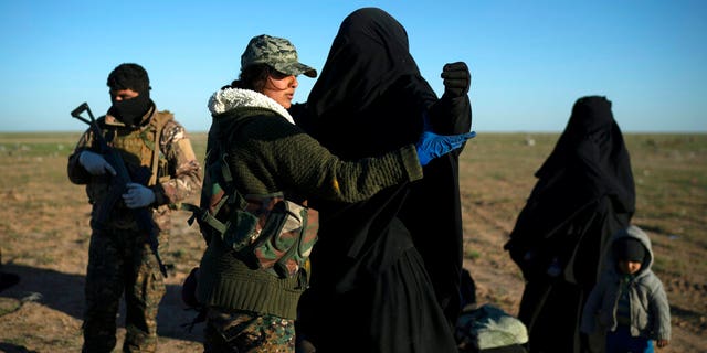 In this March 1 file photo, a woman is frisked by a U.S.-backed Syrian Democratic Forces (SDF) fighter at a screening area after being evacuated out of the last territory held by Islamic State group militants, in the desert outside Baghouz, Syria.