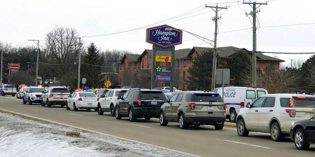 Area law enforcement vehicles gather near the scene of a shooting in Rockford, Ill., Thursday.