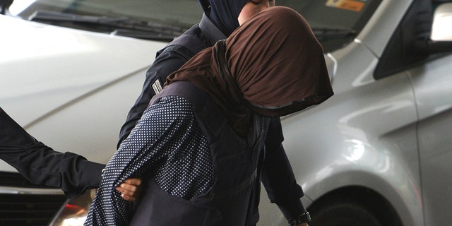 Vietnamese Doan Thi Huong foreground is escorted by police as she arrives at Shah Alam High Court in Shah Alam Malaysia Monday